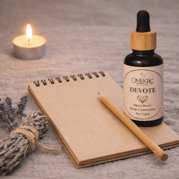 Devote, mezcla de aceites esenciales para amor y conexión, frasco junto a bolígrafo y cuaderno, estilo ritual, etiqueta visible, The Magic Apothecary
