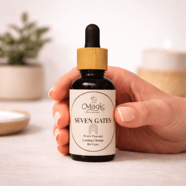 Seven Gates, essential oil blend for courage and transformation, hand holding the dropper, warm editorial light, The Magic Apothecary
