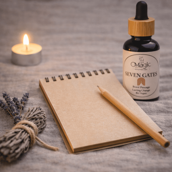 Seven Gates, essential oil blend for courage and transformation, bottle beside a pen and notebook, ritual styling, label visible, The Magic Apothecary