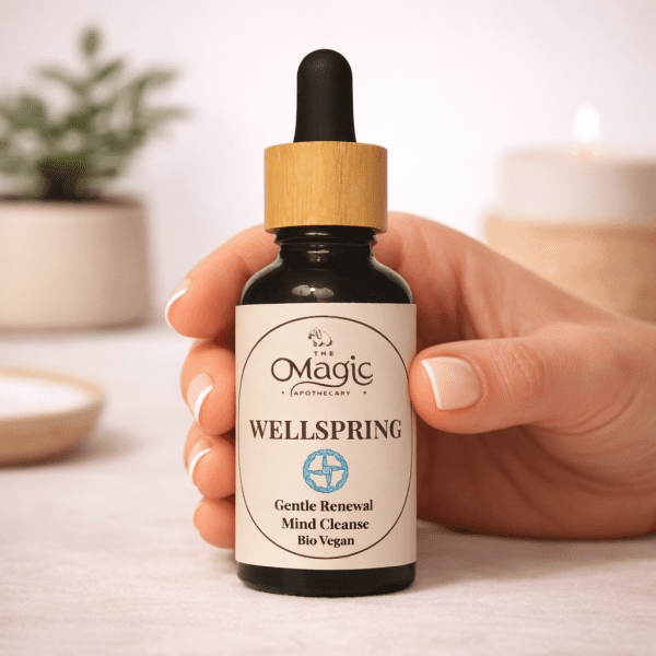 Wellspring, miscela di oli essenziali per rinnovo gentile, mano con contagocce, luce calda editoriale, The Magic Apothecary